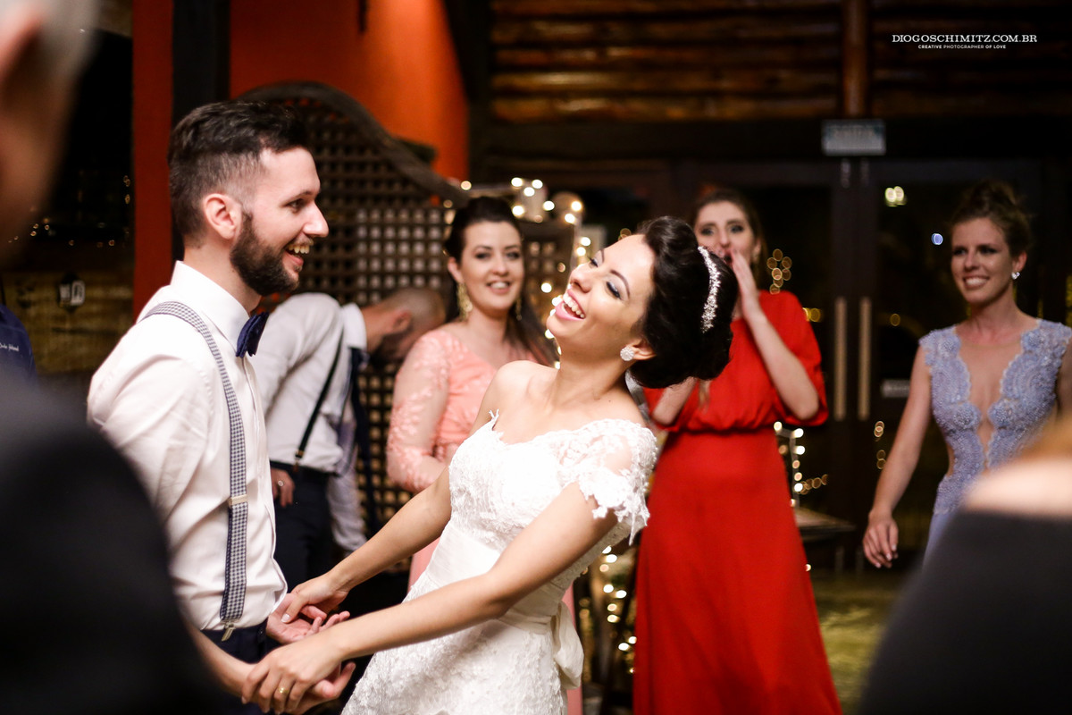 Noiva sorri e se diverti com o noivo no seu casamento no campo.