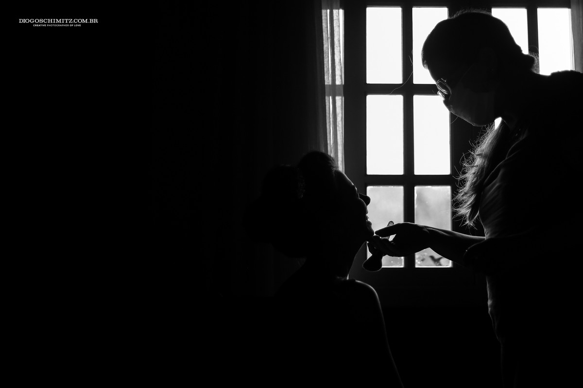 Noiva sendo maquiada para o seu casamento no campo.