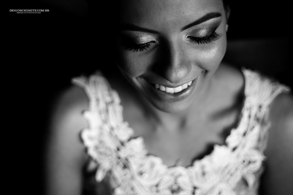 noiva sorrindo ao ser maquiada para o seu casamento no campo.