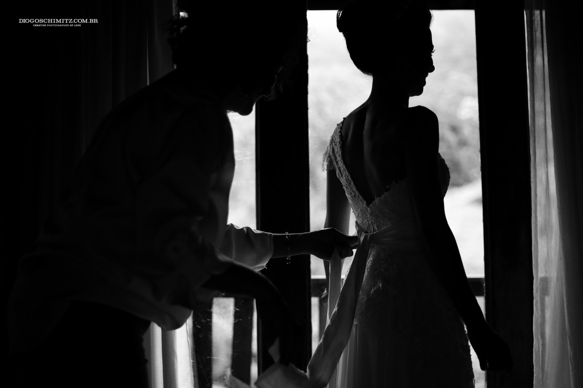 Noiva colocando o vestido para o seu casamento no campo.