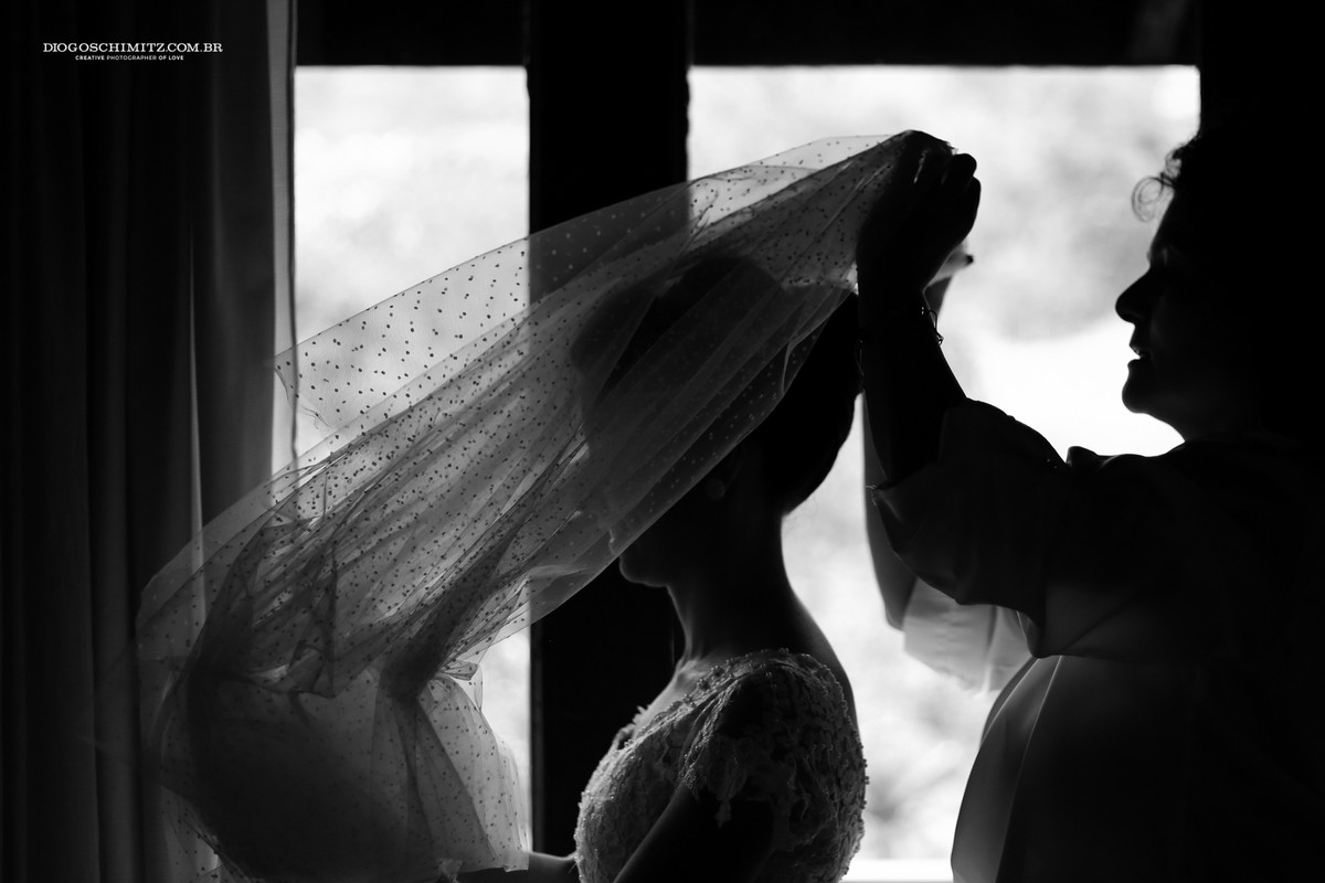 Noiva colocando o véu para o seu casamento no campo.