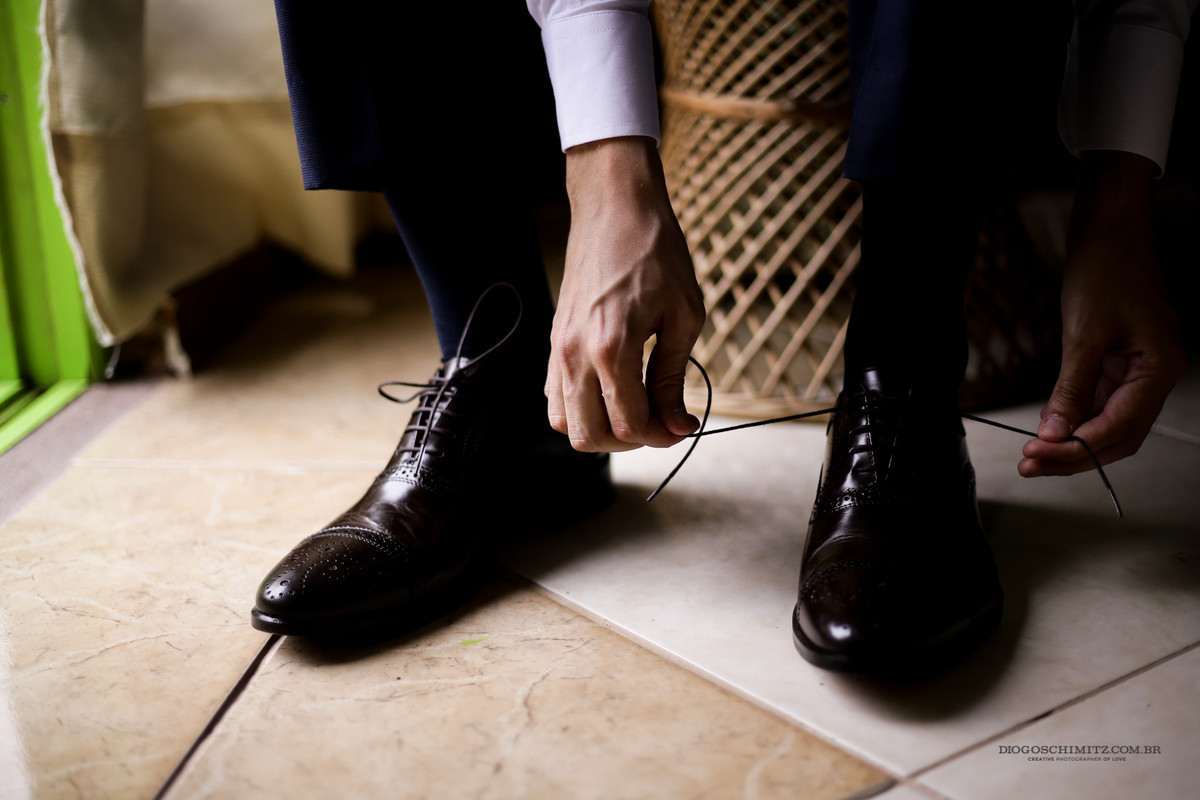 Arumando o cadarço do seu sapato Louie para o casamento no campo.