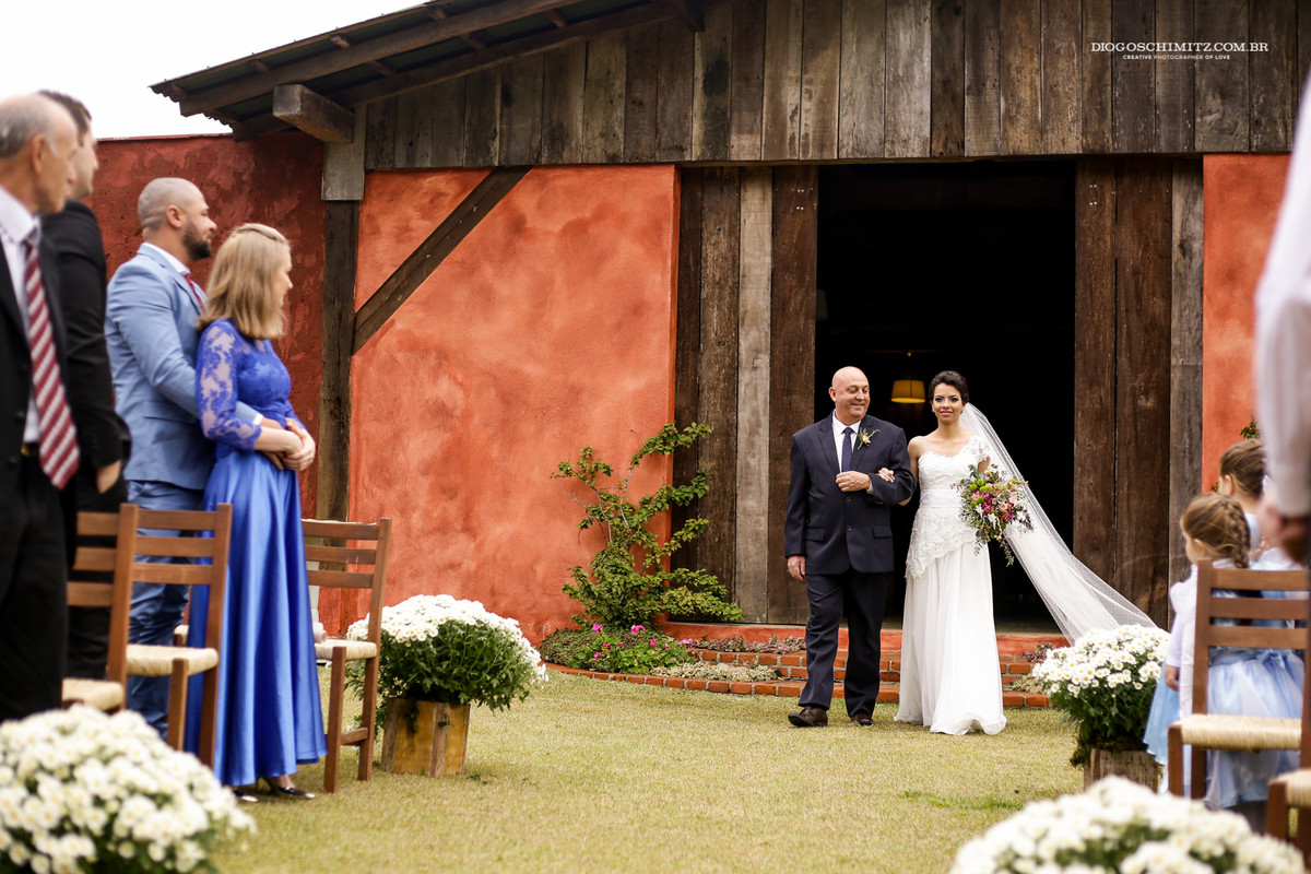 Noiva entrando com seu pai no casamento no campo.