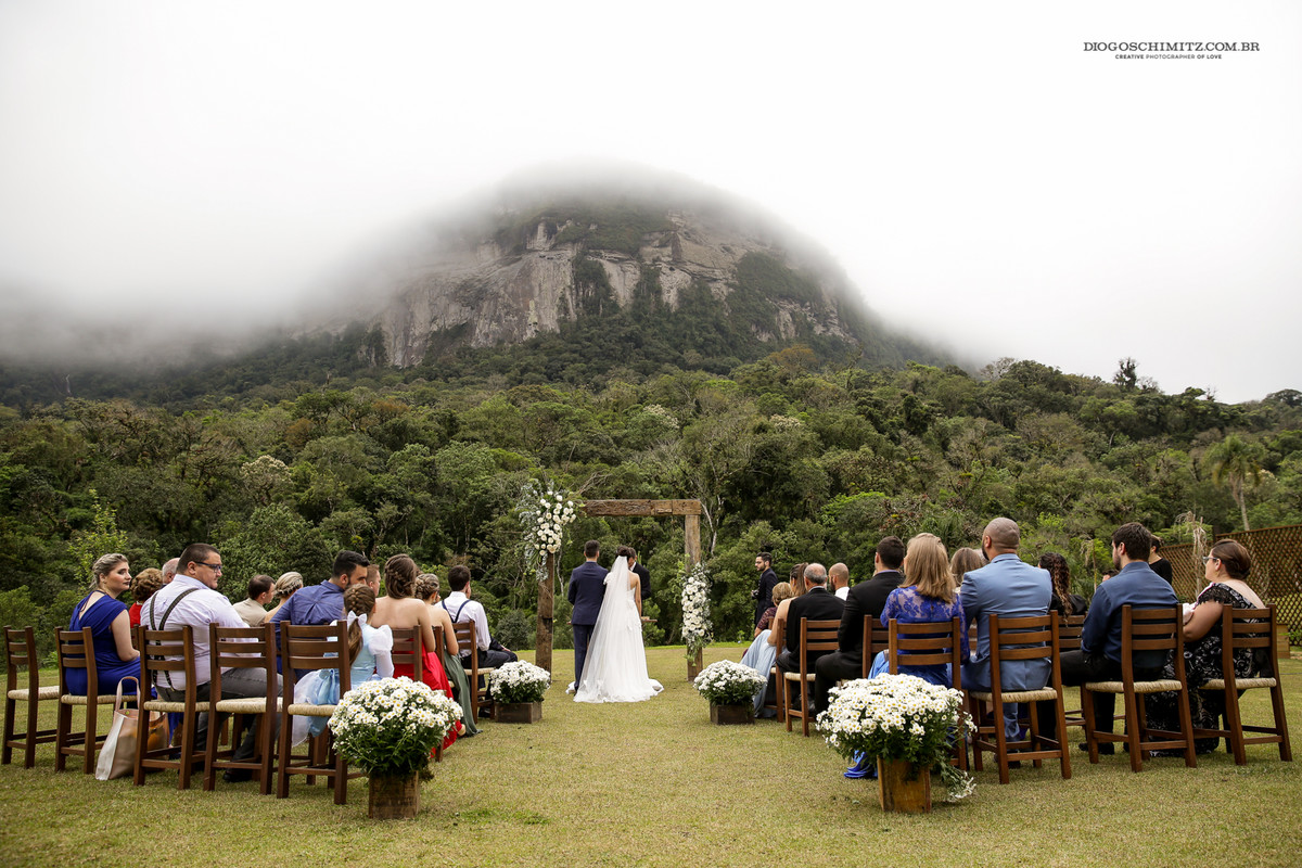 Vissão aberta da cerimônia no canto, com a neblina no topo do morro ao fundo.