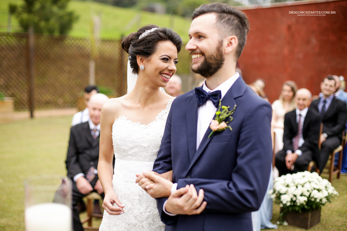 Noiva sorri para os seus pais que estão sentado.