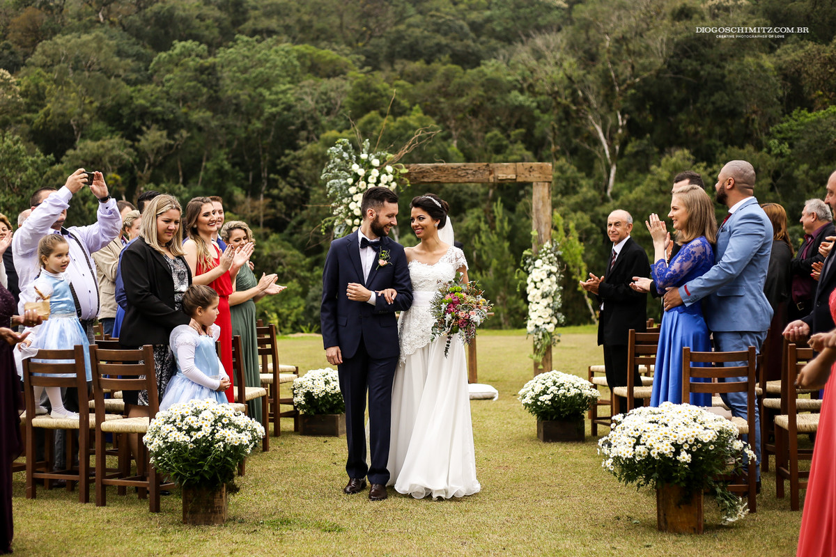Momento da saída dos noivos da cerimônia no campo.