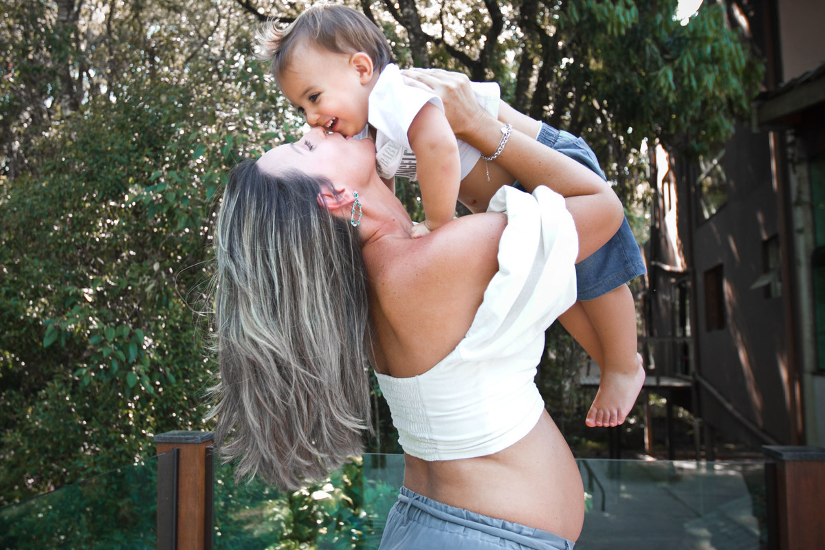 fotografia de Gestante levantando o filho mais velho