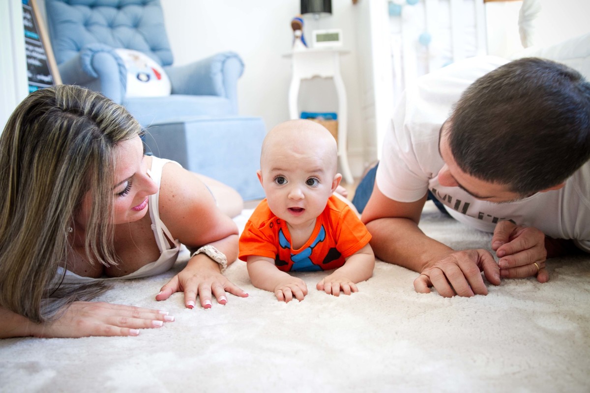 Fotografia de família os pais olhando para o bebê