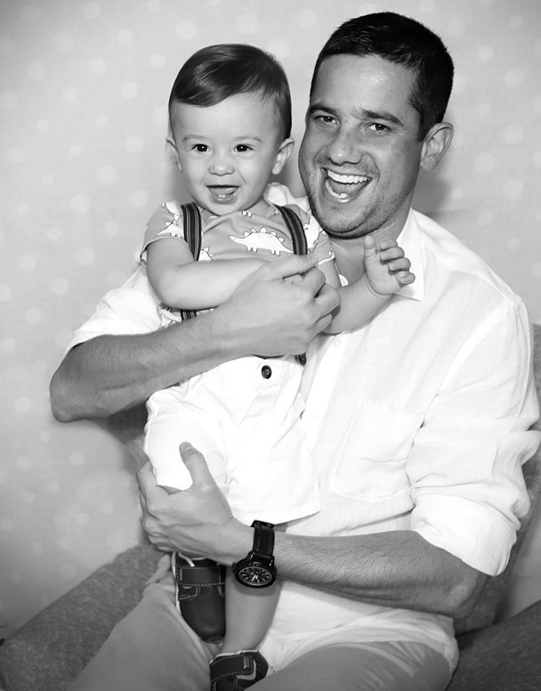 Fotografia em preto e branco  do bebê brincando e sorrindo com o pai-Rio de Janeiro- RJ