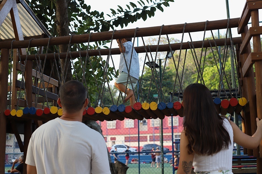 Fotografia dos pais olhando o filho em um brinquedo de parquinho - Rio de Janeiro - RJ