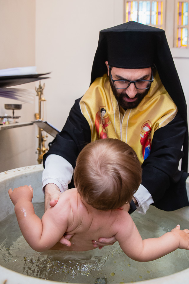 mergulhando benjamin na agua para o batizado ortodoxo