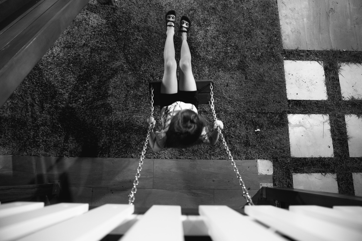 menina no balanço vista de cima, menina brincando de balanço foto pb