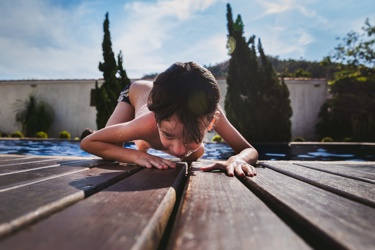 video documental de familia , familia porto kastrup , mansao itacoatiara , caio na beira da piscina olhando pela fresta do deck da piscina 