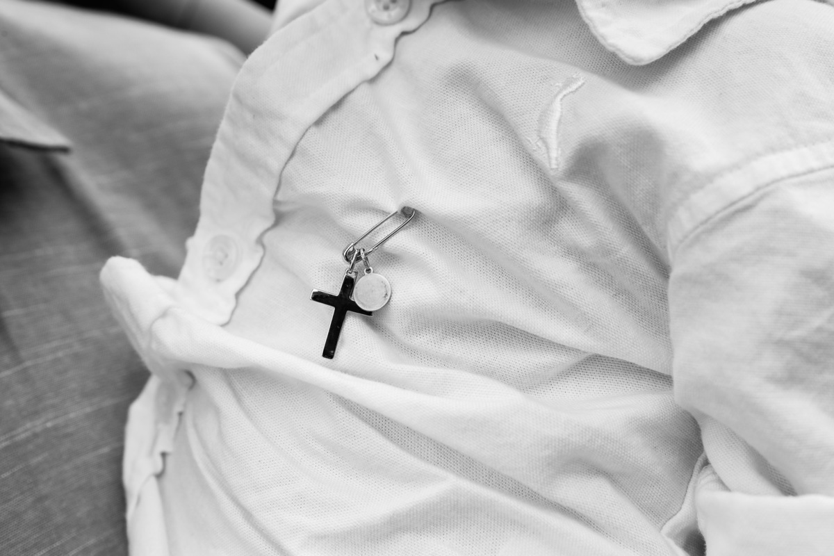 criança com medalhinha de crucifixo