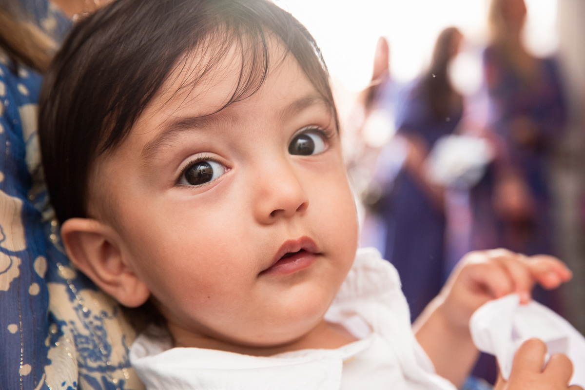 familia participando do batismo criança olhando pra foto no batizado