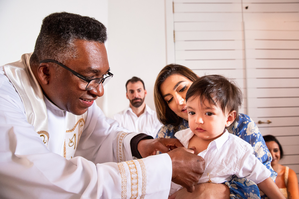 familia participando do batismo bençao do padre óleo batismal