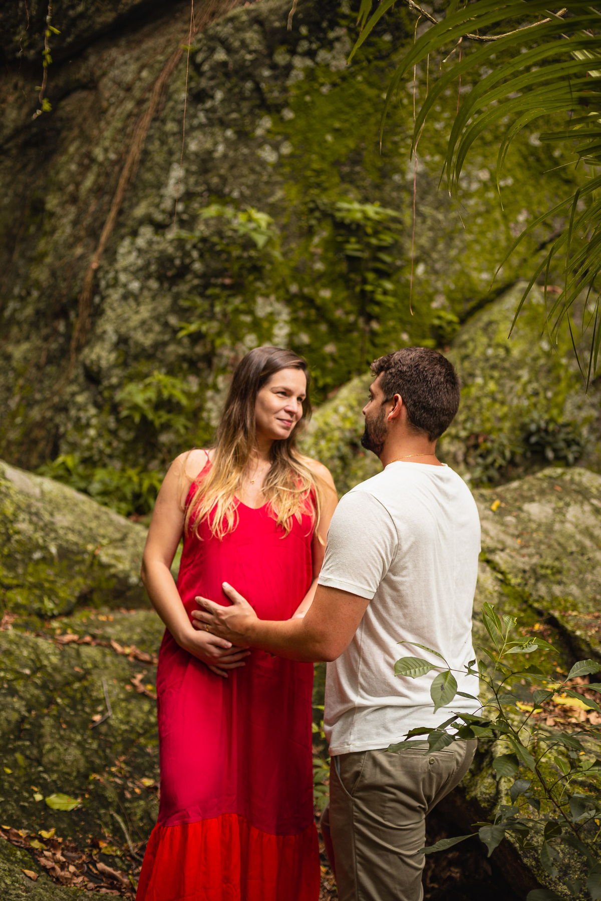 casal gestante se olhando com as maos na barriga
