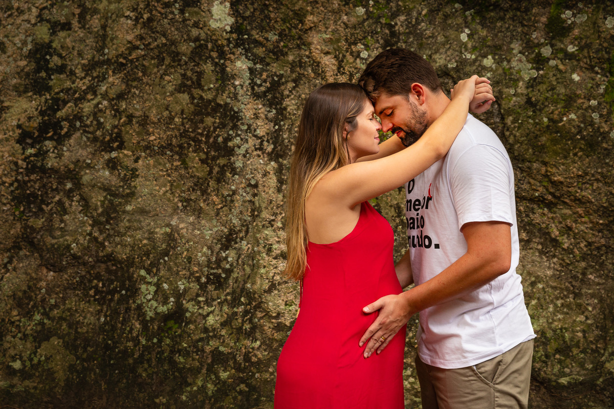 casal gestante de frente um pro outro testa com testa maos na barriga 