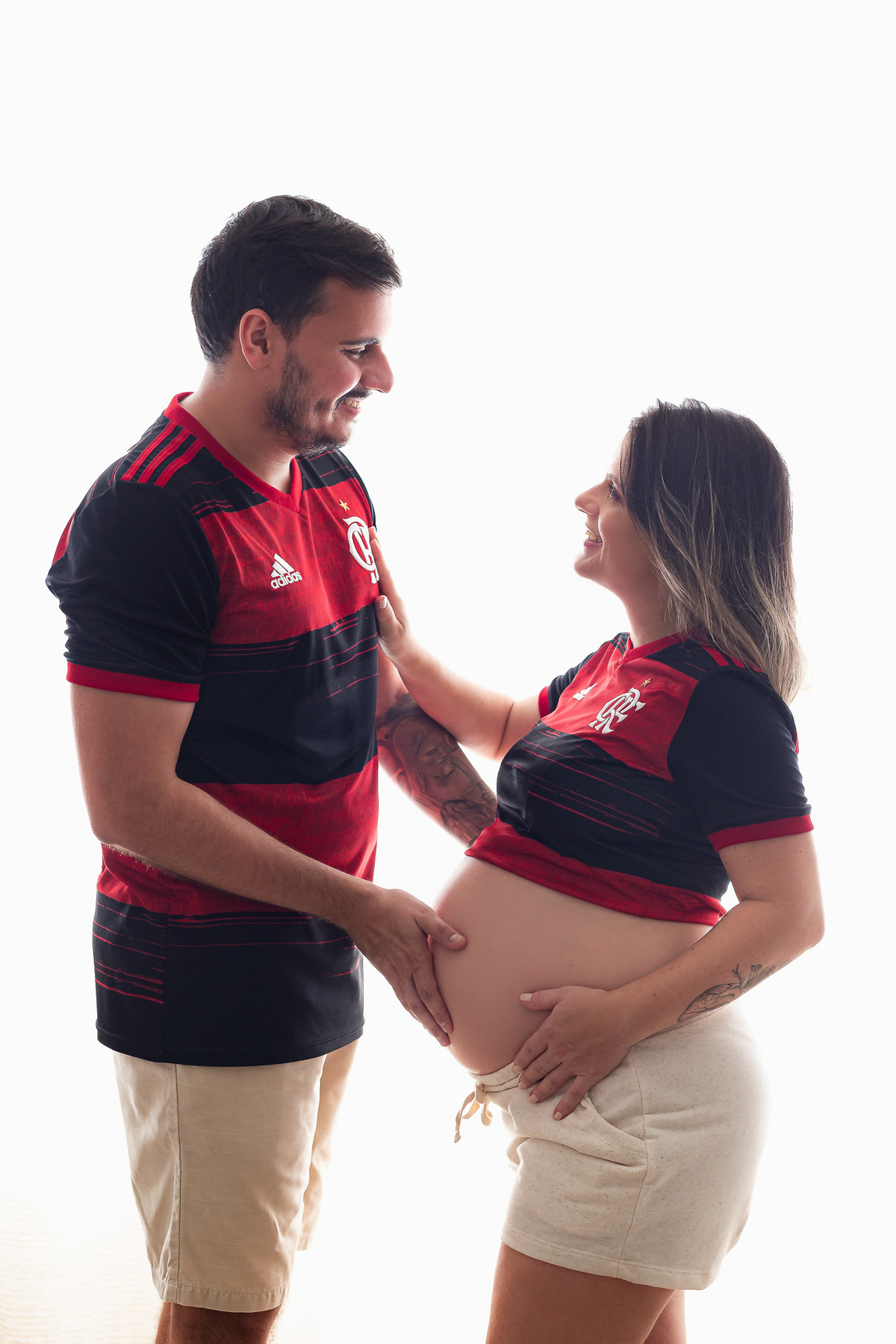 casal flamenguista com 30 semanas de gestação posando pra foto com as mãos na barriga