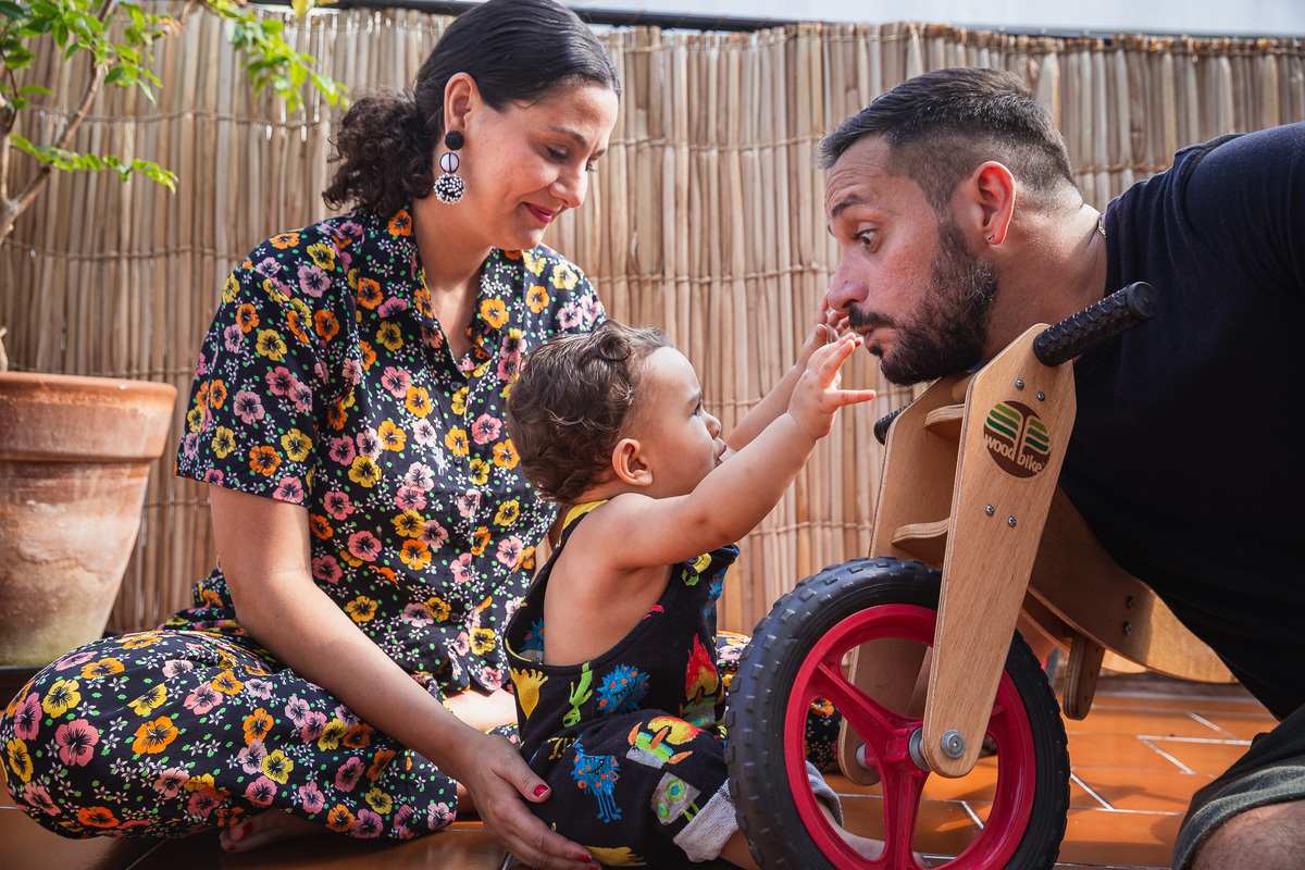 ensaio fotografico de família em casa bonjour vicente foto de criança brincando com os pais na varanda