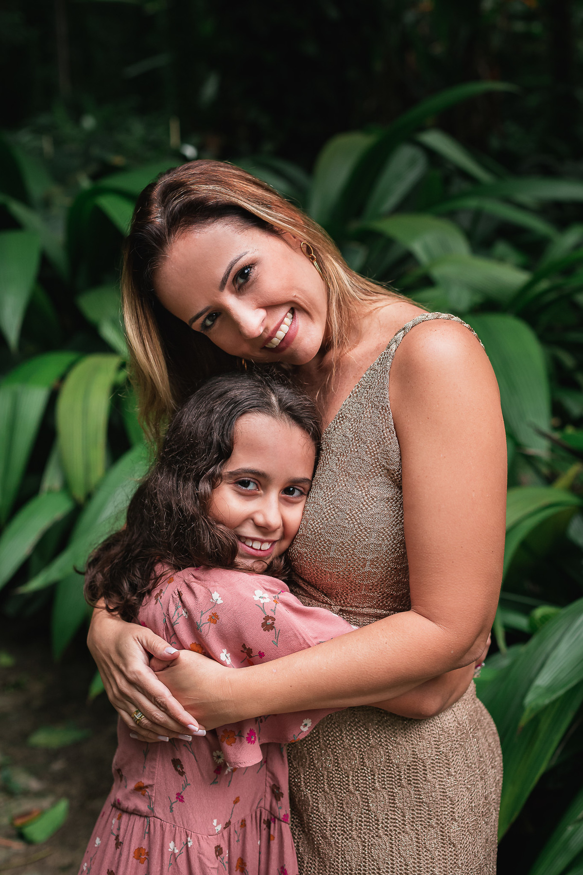 Ensaio fotografico de familia no parque lage mae abraçada com filha com folhas verdes de fundo