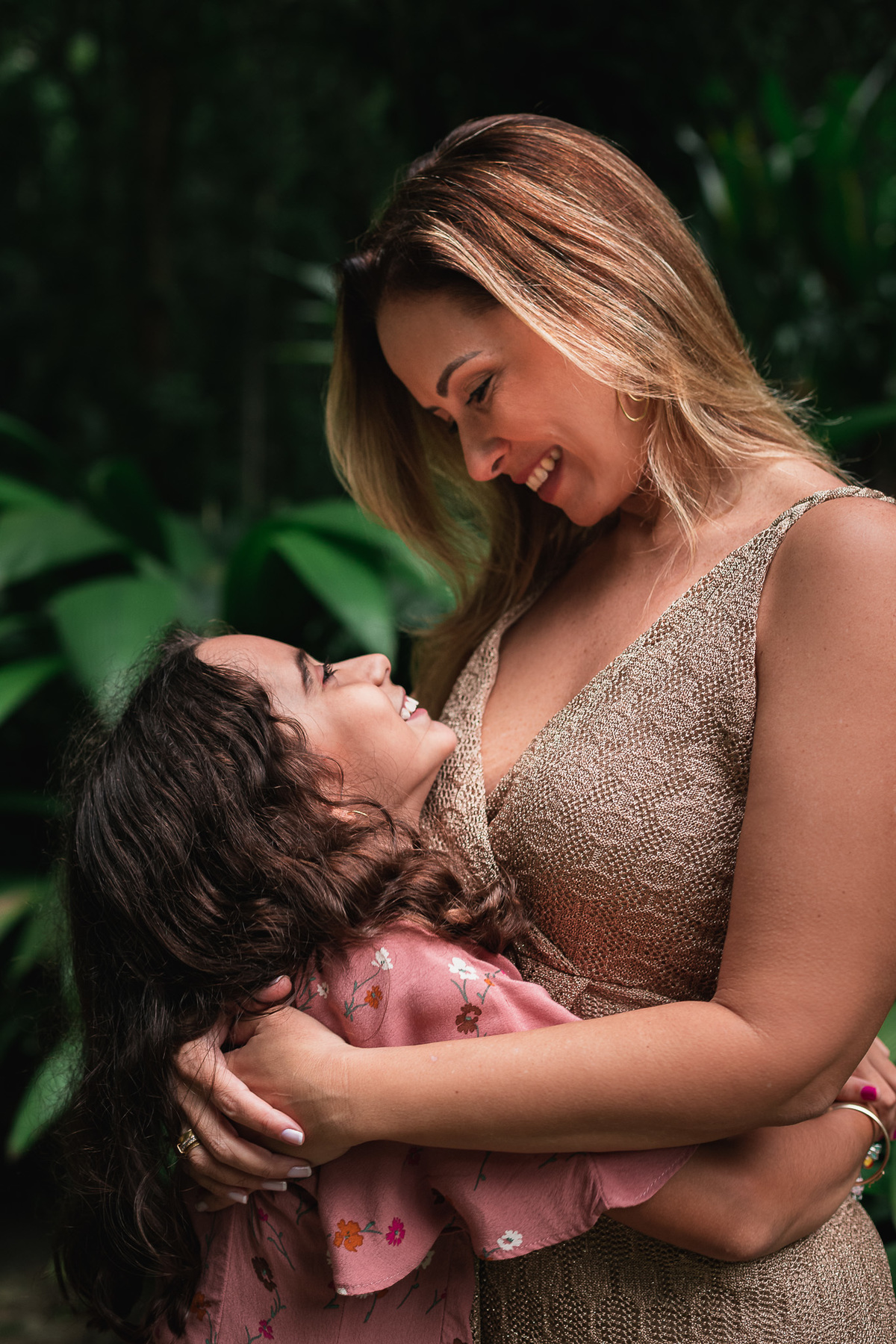 Ensaio fotografico de familia no parque lage mae abraçada com filha com folhas verdes de fundo