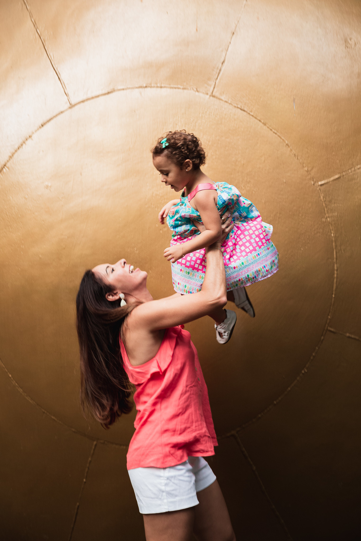 ensaio fotografico em familia no parque da catacumba mae jogando a filha pro alto e segurando