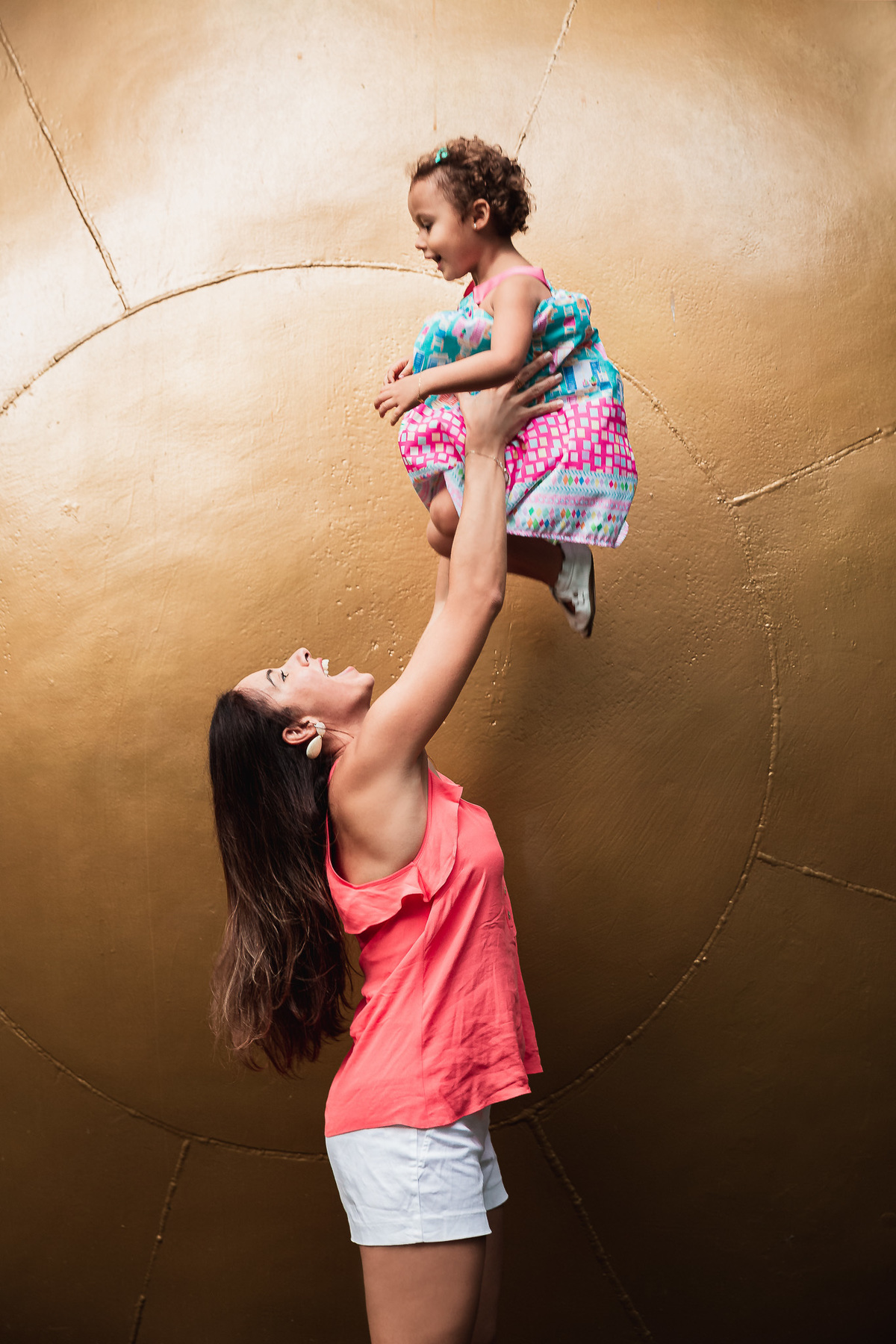 ensaio fotografico em familia no parque da catacumba mae jogando a filha pro alto e segurando