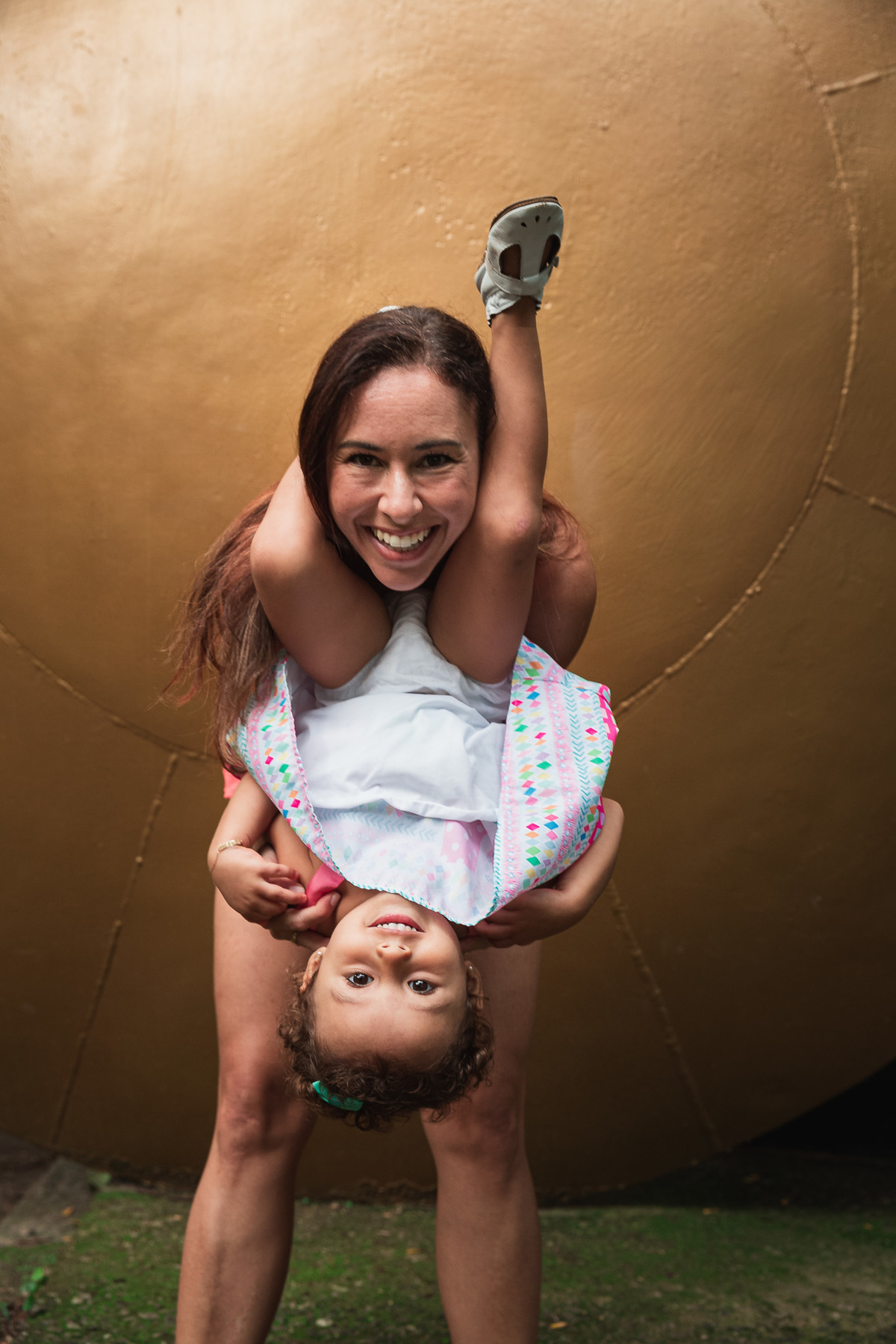 ensaio fotografico em familia no parque da catacumba mae jogando a filha pro alto e segurando