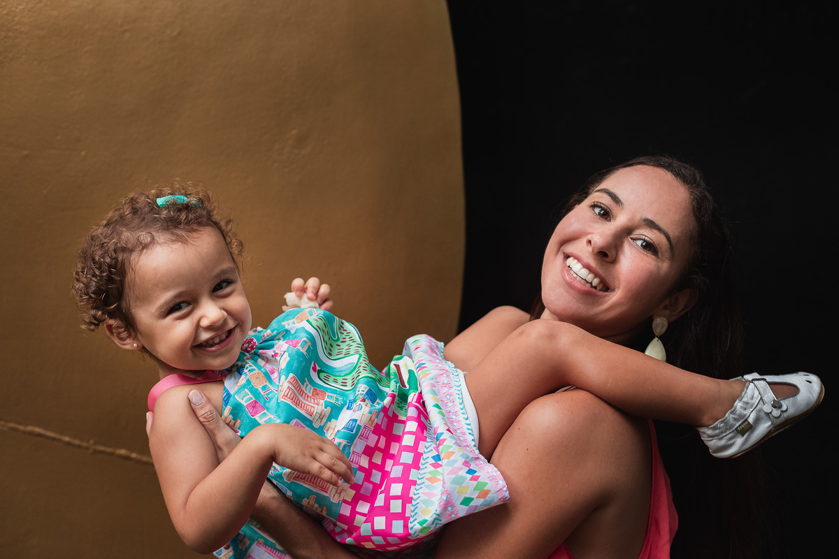 ensaio fotografico em familia no parque da catacumba mae jogando a filha pro alto e segurando