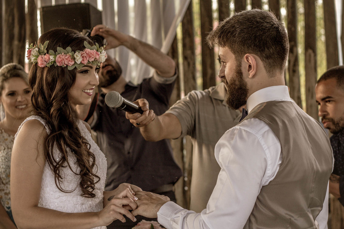 palestrante com microfone para noiva fazendo votos ao noivo com a aliança no click do fotógrafo de casamento Bauru Thiago Figueredo sorrindo