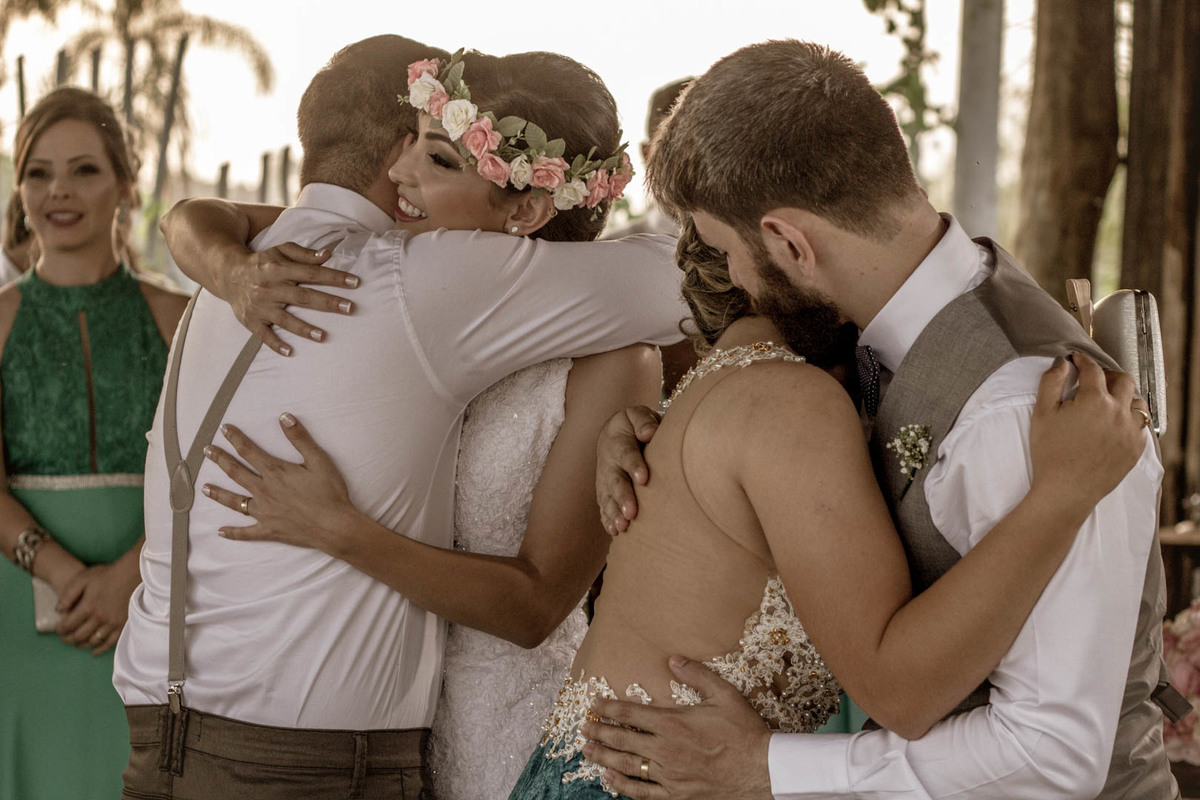 abraçando padrinhos os noivos comemoram no click do fotógrafo de casamento Bauru Thiago Figueredo após selarem o casamento