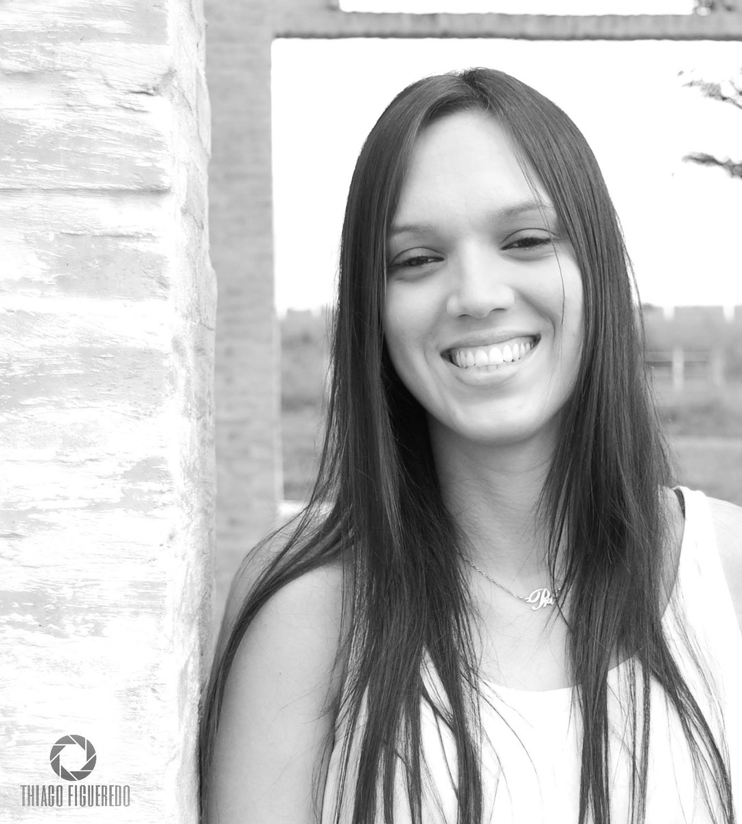 Sorriso contagiante da Priscila em seu ensaio fotográfico pelo fotógrafo de ensaio de Jaú encostada no murinho, foto em preto e branco