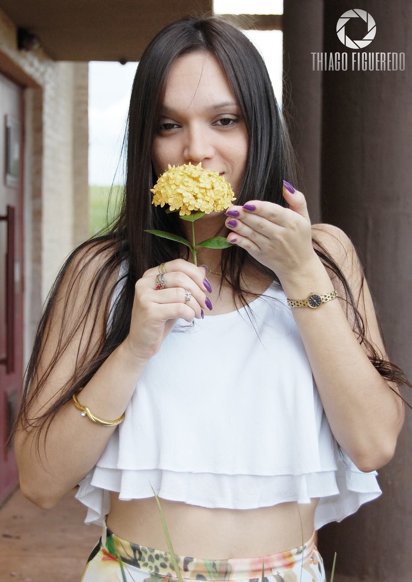 A mais bela flor, Priscila e a flor ilustram essa linda fotografia em seu ensaio ensaio fotográfico pelo fotógrafo de ensaio de Jaú oferecendo a flor ao espectador