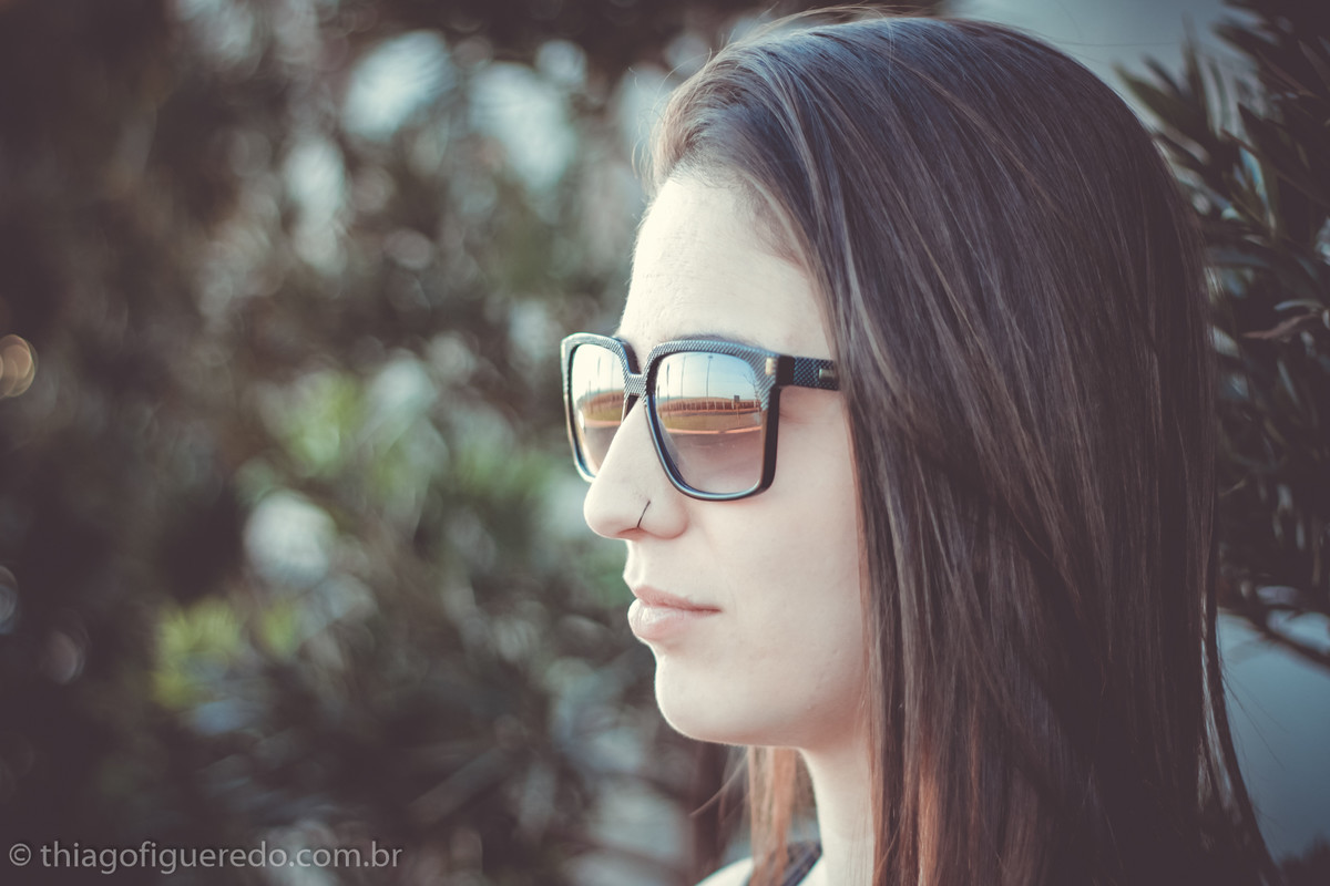 de óculos escuros com plantas atrás a Bruna admira a natureza no click do fotógrafo de ensaio fotográfico de jaú e região Thiago Figueredo 