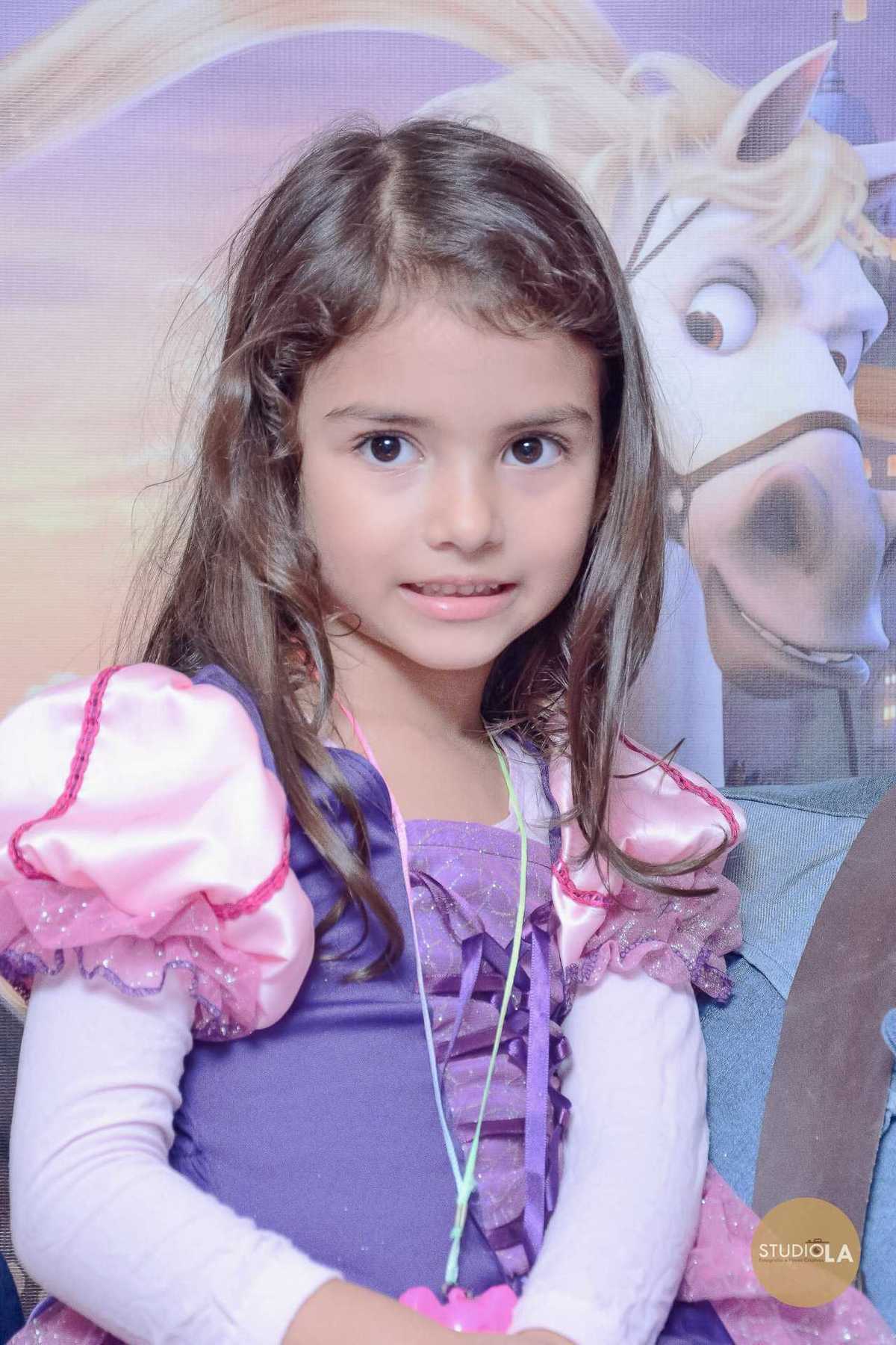 Retrato da aniversariante em sua festa temática, vestida de princesa, com um lindo cenário ao fundo. Fotografia de festa infantil feita pelo Studio LA em SP.