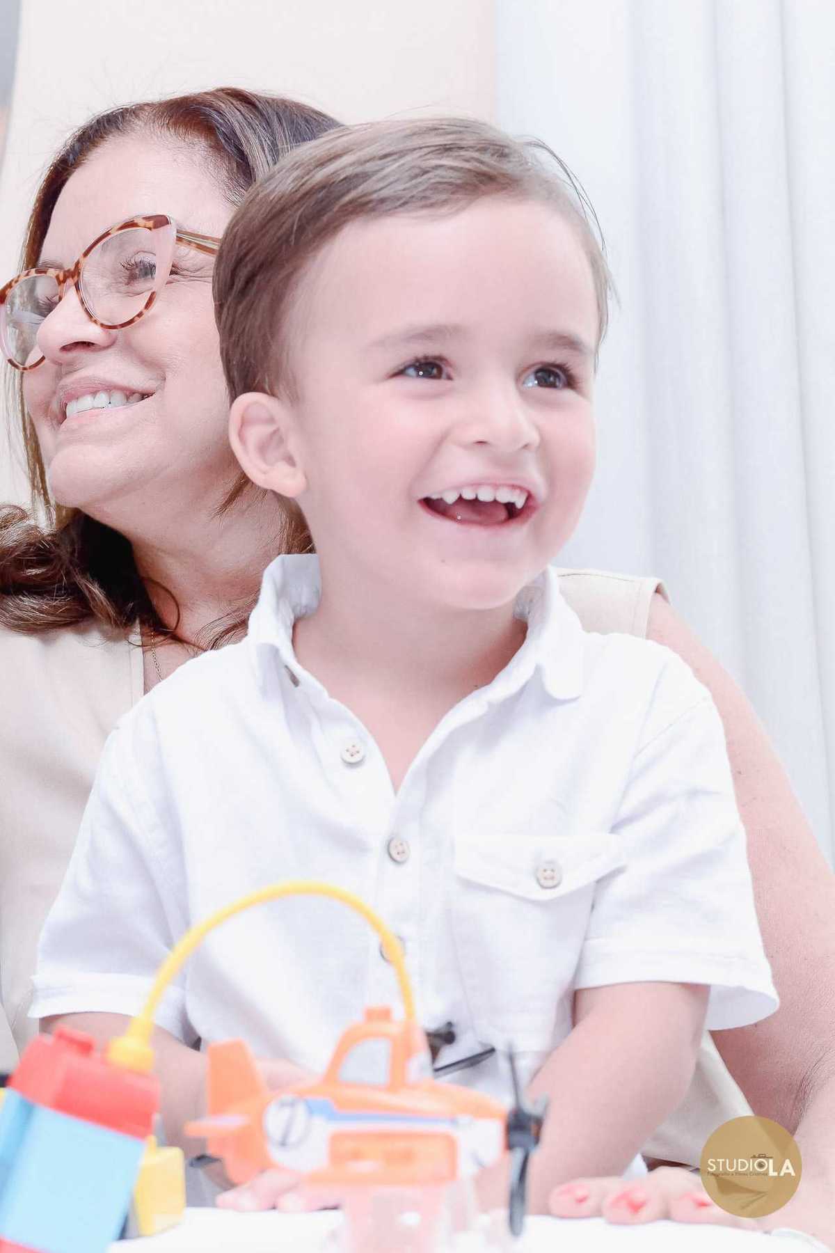 Retrato espontâneo de criança sorridente durante sua festa de aniversário em São Paulo, registrado com carinho pelo Studio LA.