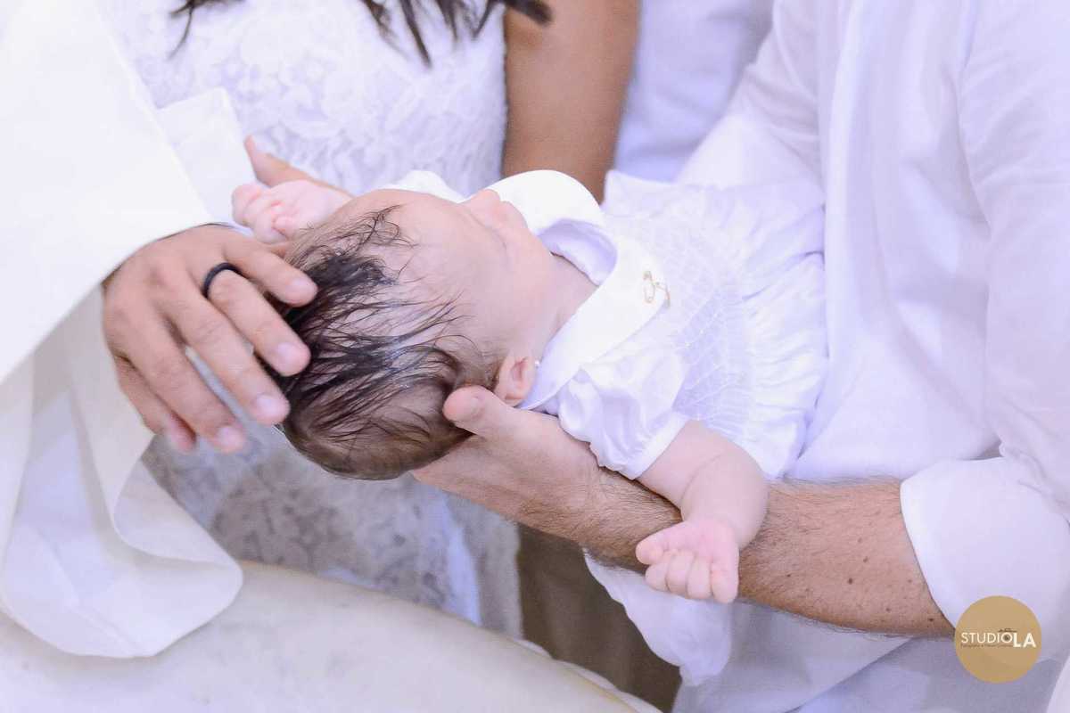 Detalhe emocionante do batizado na Igreja Católica em São Paulo: o bebê recebe a água benta em seu batismo, em um momento cheio de fé e ternura. Registro feito pelo Studio LA.