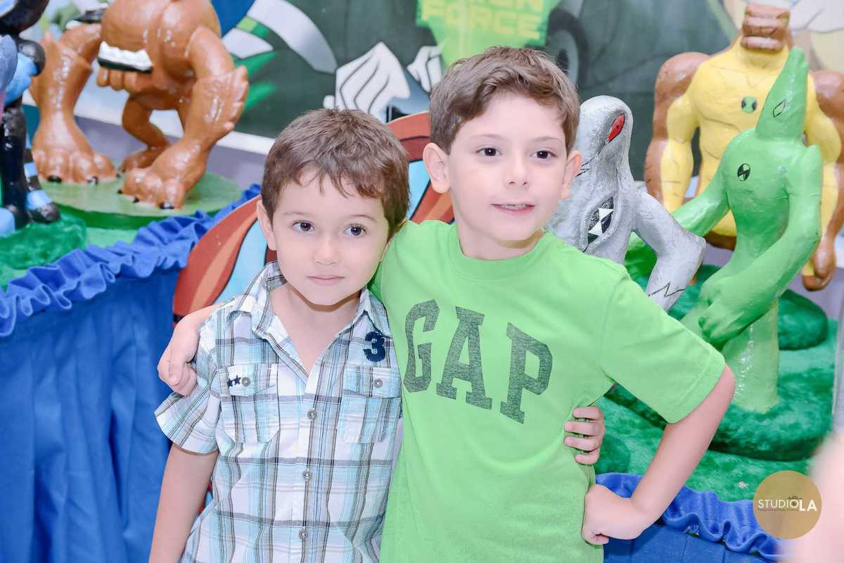 Dois amigos posando juntos em frente à mesa decorada com tema de super-heróis, em um aniversário cheio de cores e diversão — fotografias de festa infantil feitas pelo Studio LA.