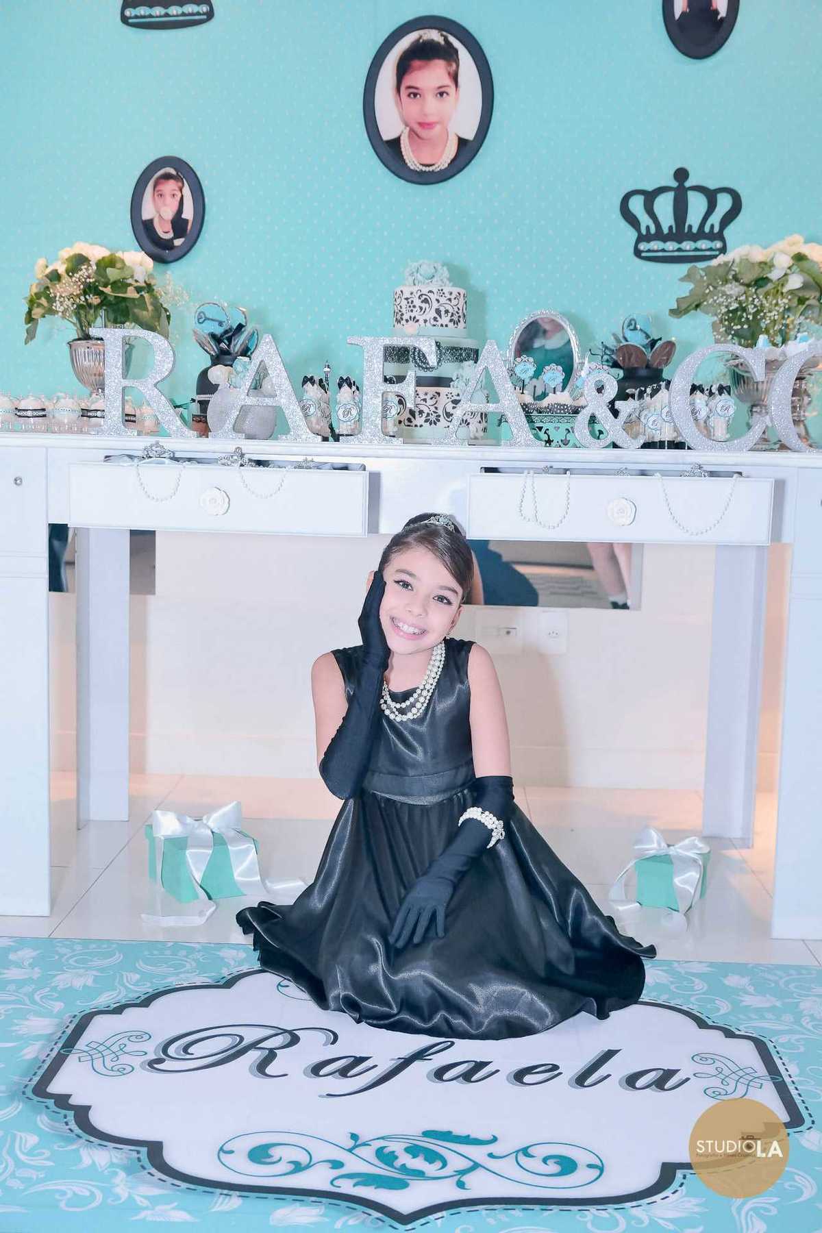 A aniversariante posa diante da mesa decorada com o tema personalizado, transmitindo charme e felicidade. Fotografia de festa infantil captada pelo Studio LA.
