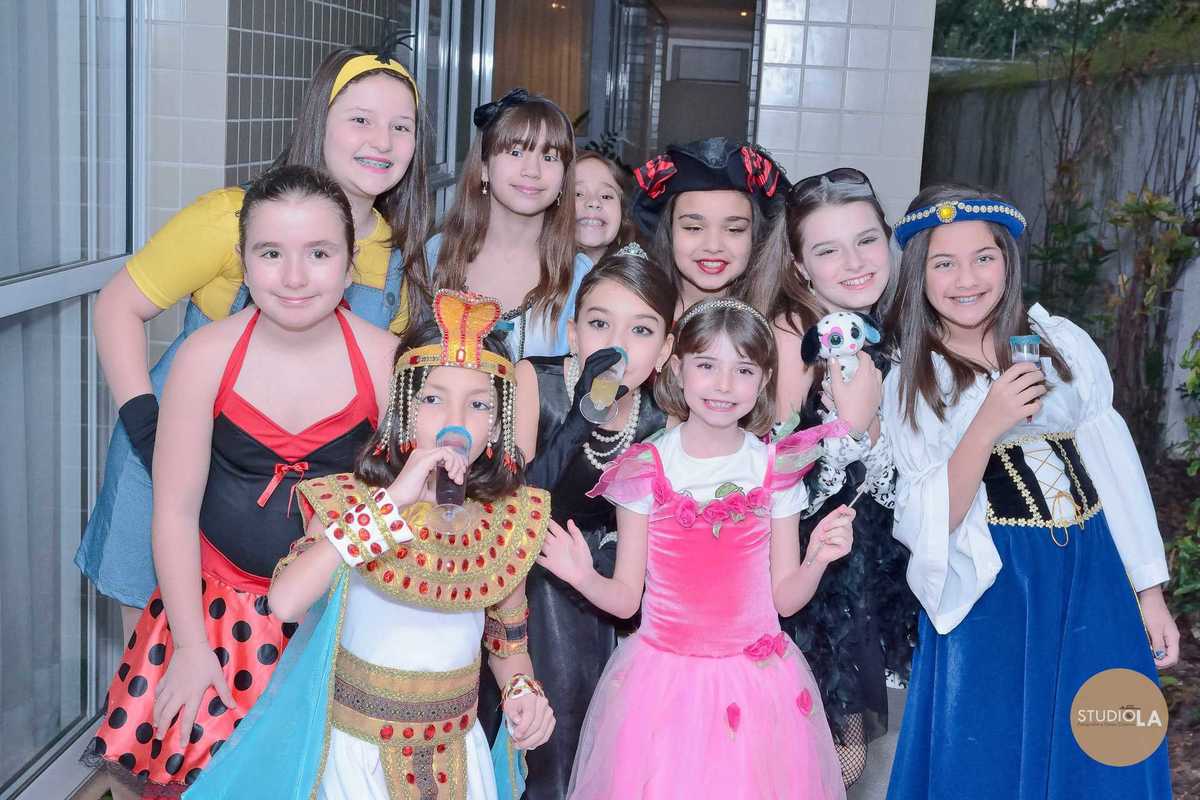 Grupo de amigas fantasiadas e sorridentes, aproveitando cada detalhe da festa temática. Fotografia de festa infantil feita pelo Studio LA.
