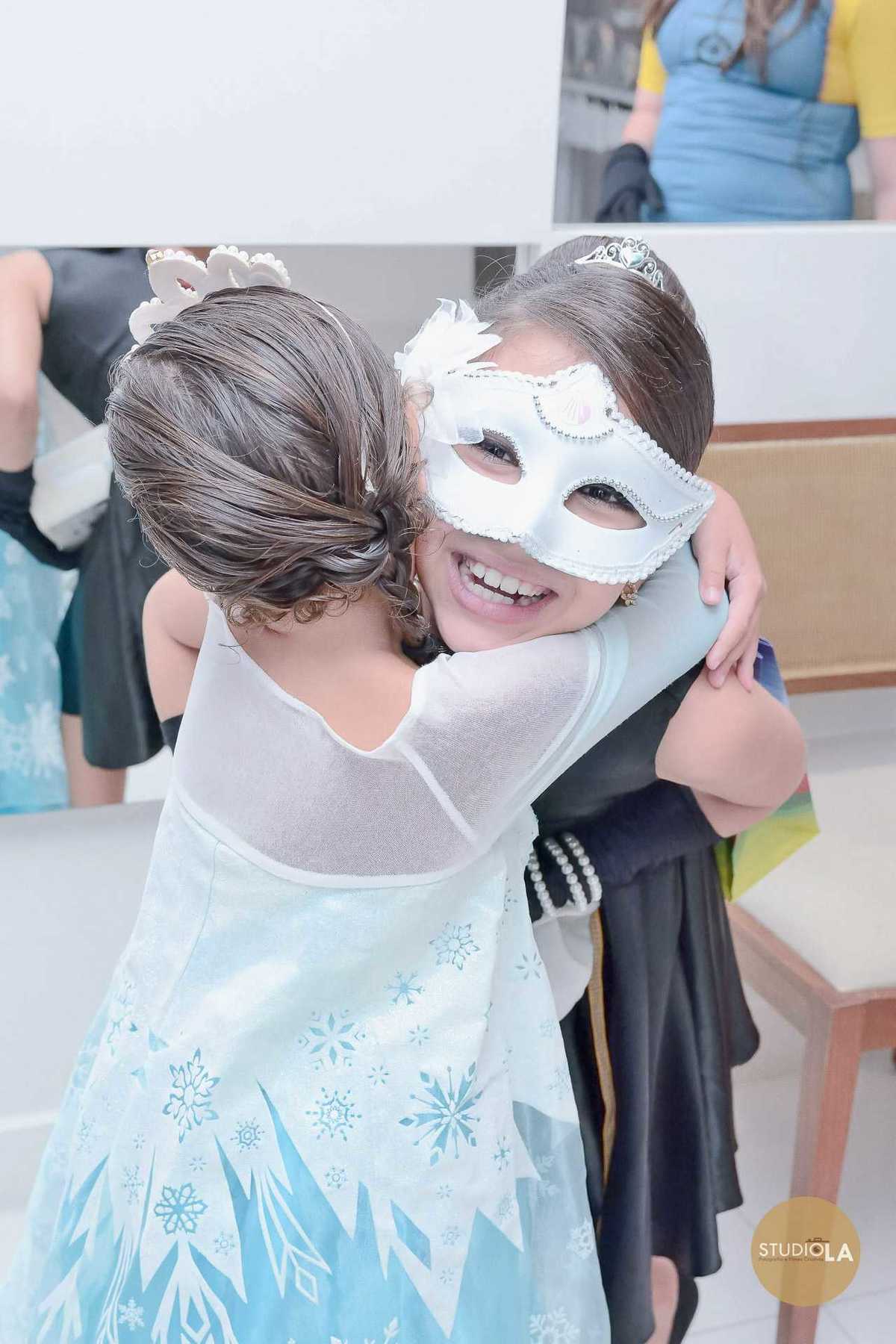 Abraço carinhoso entre amigas fantasiadas, simbolizando a amizade e a alegria de viver esse dia especial. Fotografia de festa infantil em São Paulo registrada pelo Studio LA.