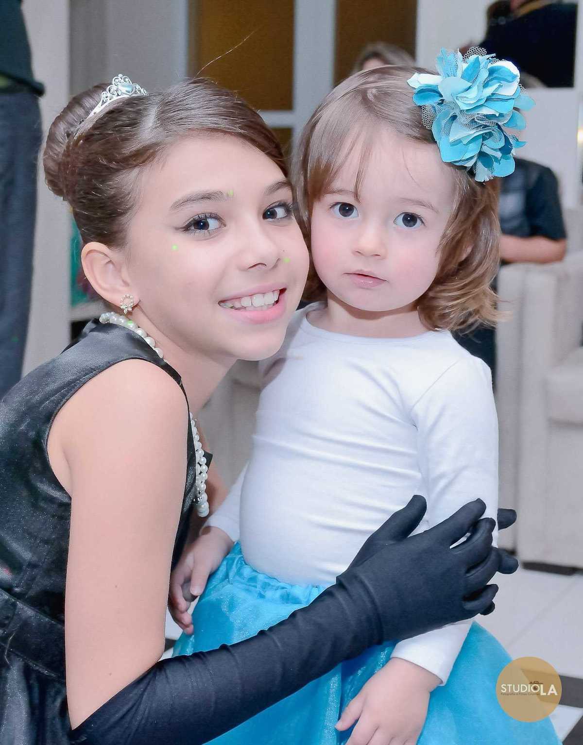 Uma linda fotografia de festa infantil em São Paulo, feita pelo Studio LA, registrando a aniversariante abraçada com uma criança convidada, em um momento de carinho e ternura.