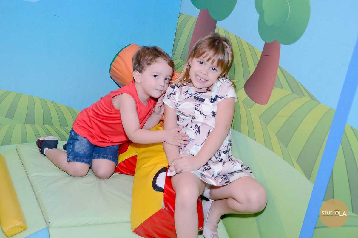 Registro carinhoso dos irmãos brincando juntos no espaço kids durante a festa infantil no Buffet Feliz da Vida em São Paulo — Studio LA.