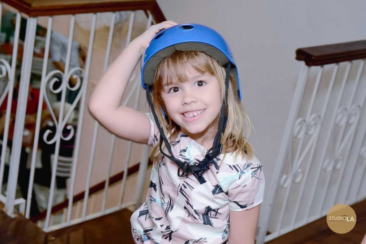 Uma princesa sorridente com capacete azul em um momento divertido durante a festa infantil. Fotografia de aniversário registrada pelo Studio LA em São Paulo.