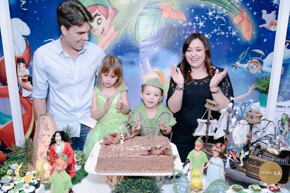 Momento de celebrar: família reunida ao redor do bolo em uma linda festa infantil com tema Peter Pan. Fotografia profissional do Studio LA em São Paulo.