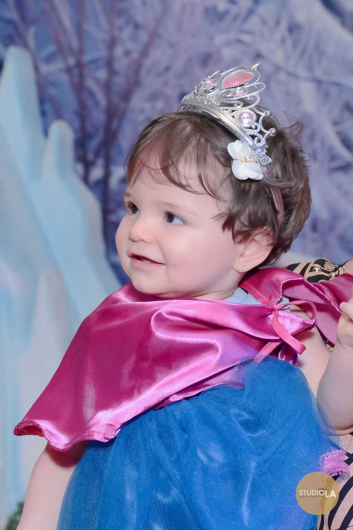 Bebê fantasiada de princesa durante festa infantil temática Frozen em São Paulo, cheia de detalhes encantadores. Registro delicado do Studio LA.