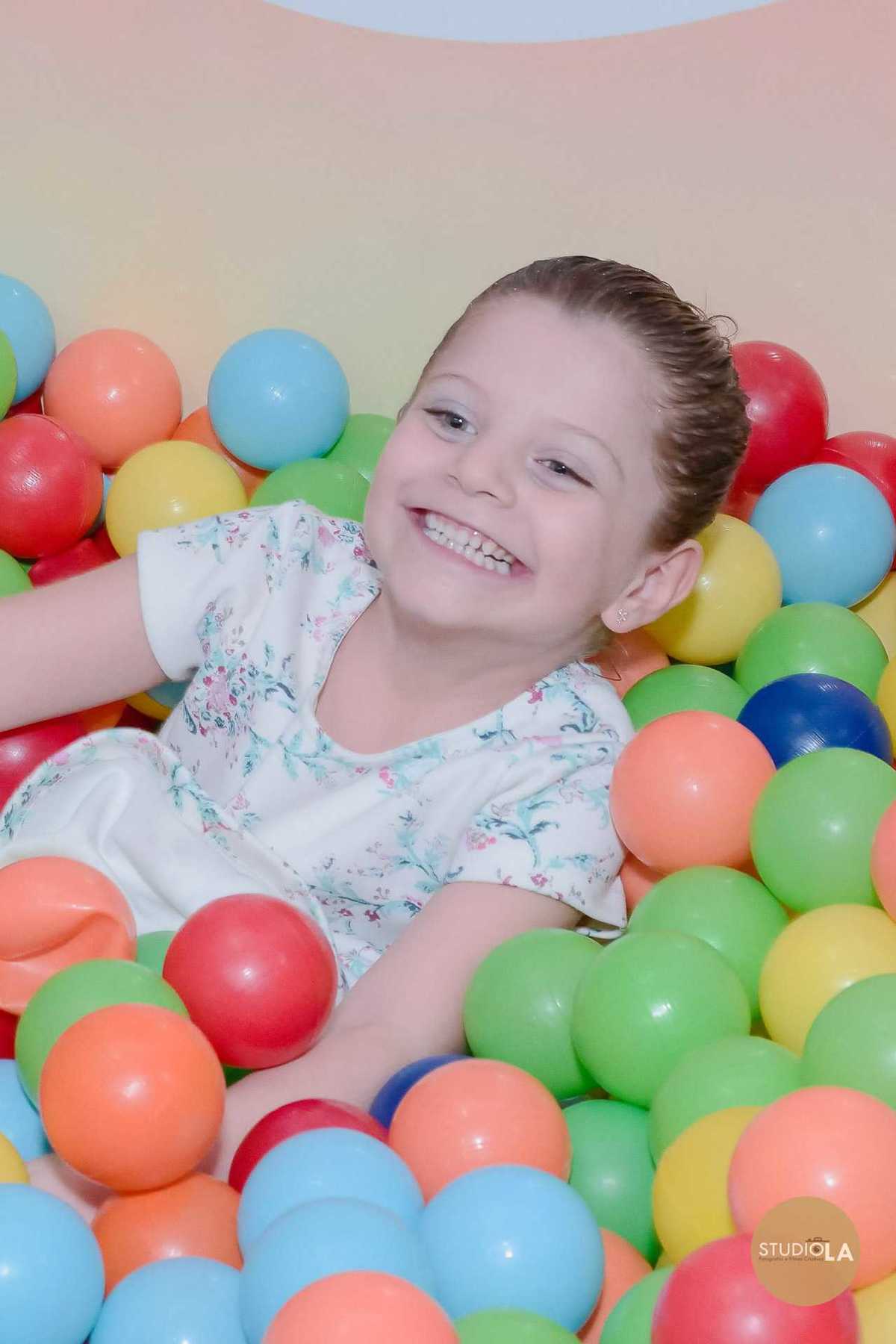 Criança aproveitando o momento de diversão no espaço de brinquedos, em piscina de bolinhas coloridas, durante festa infantil em São Paulo. Fotografia feita pelo Studio LA.