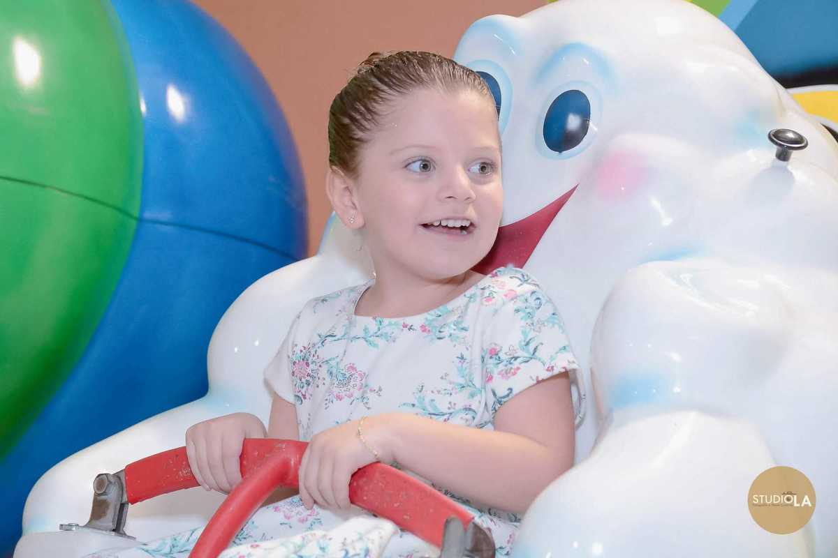 Menina sorridente curtindo brinquedo no buffet infantil em São Paulo, durante festa de aniversário com tema Frozen. Registro alegre feito pelo Studio LA.