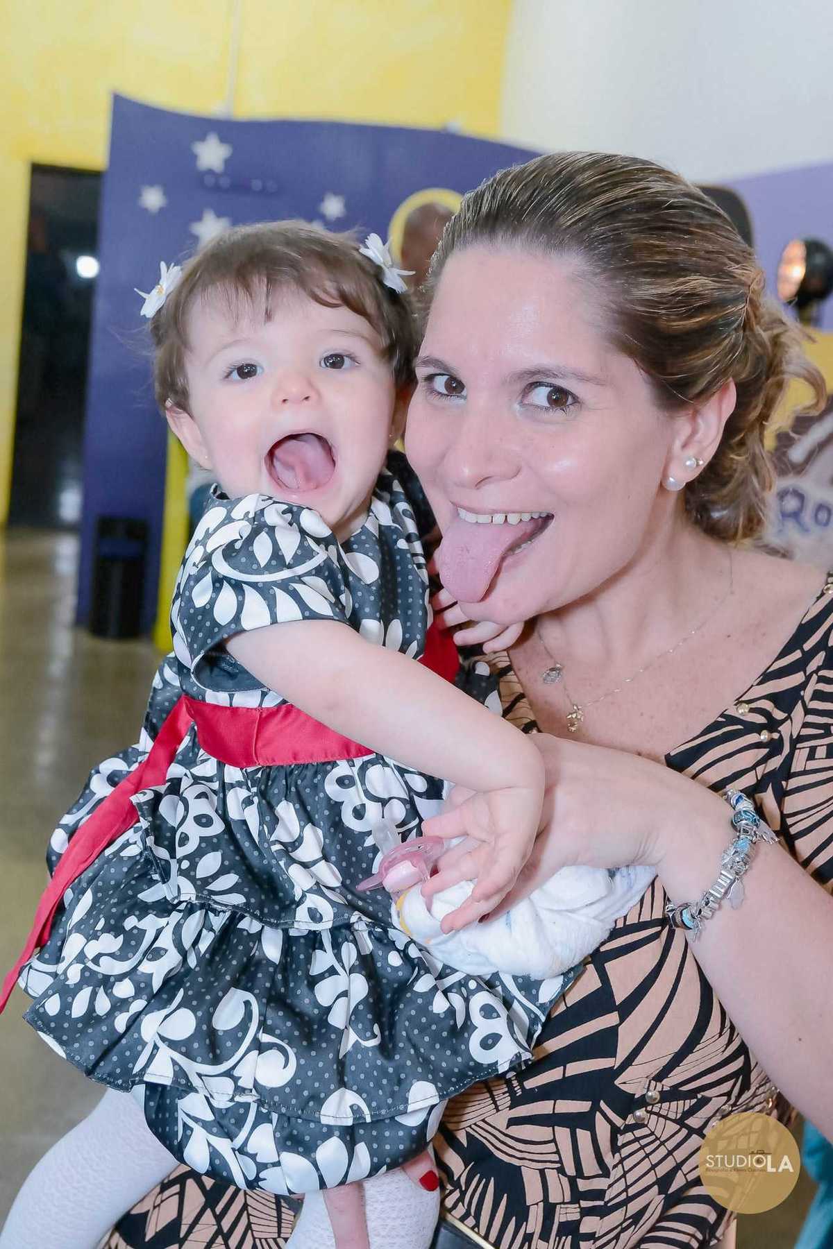 Mamãe e bebê em momento divertido durante festa infantil em São Paulo, trocando sorrisos e caretas cheias de carinho. Fotografia feita pelo Studio LA.